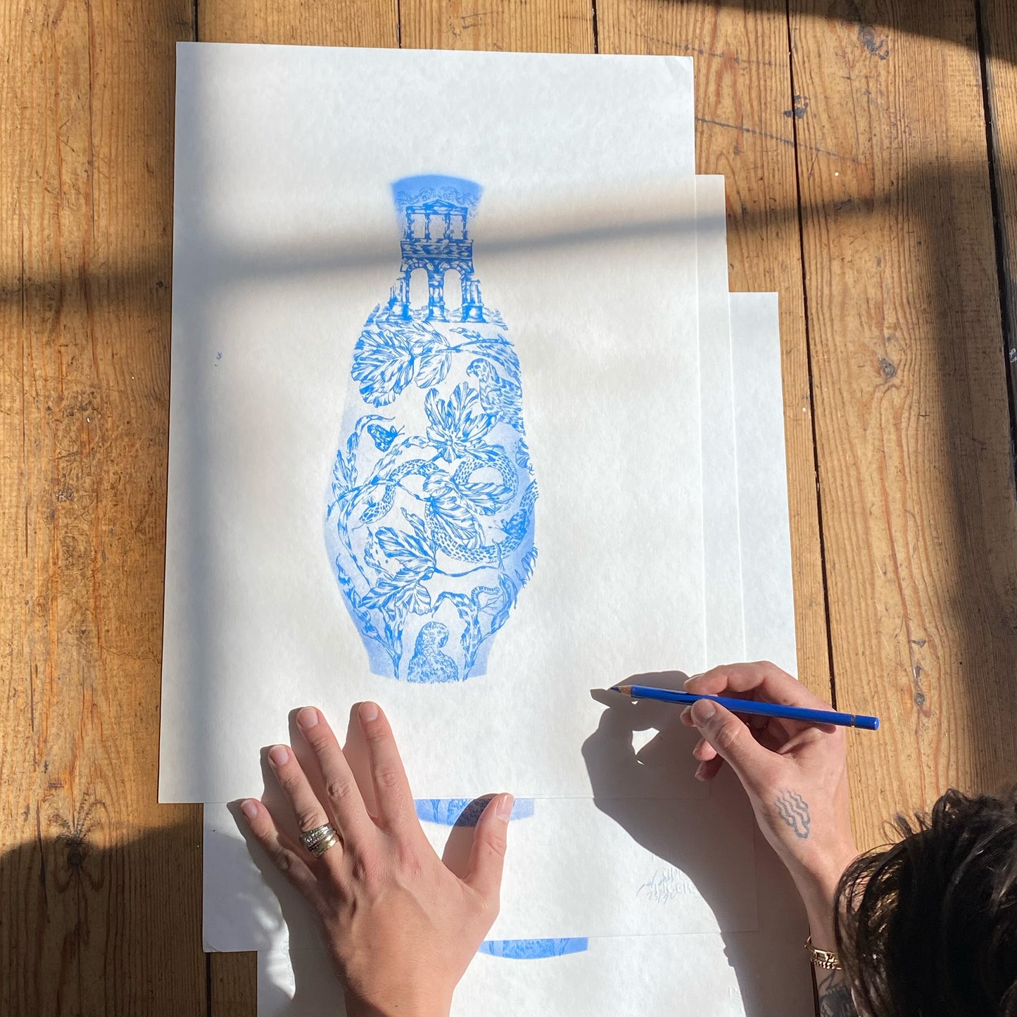 signing a screen print of blue vase